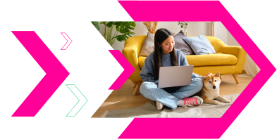 Woman using a laptop while sitting with her dog